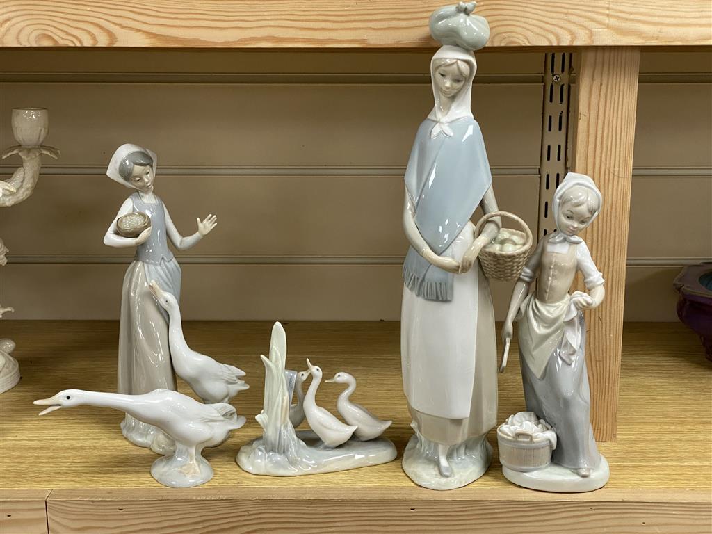 Three Lladro figures, two Nao figures.